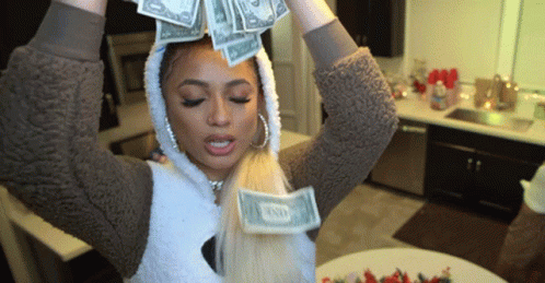 A Woman In A Hooded Jacket Is Holding A Stack Of Twenty Dollar Bills On Her Head GIF