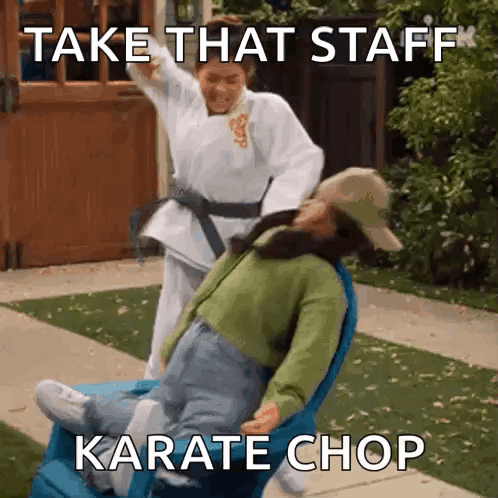 A Woman In A Karate Uniform Is Pushing A Woman In A Wheelchair . GIF