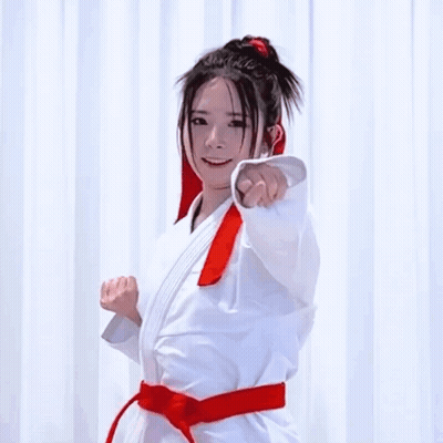 A Woman In A Karate Uniform With A Red Belt GIF