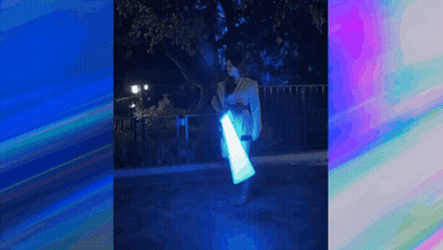 A Woman In A Kimono Is Holding A Light Saber In Her Hands . GIF