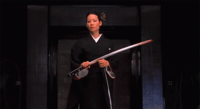 A Woman In A Kimono Is Holding A Sword . GIF
