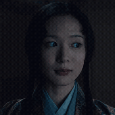 A Woman In A Kimono Is Looking At The Camera GIF