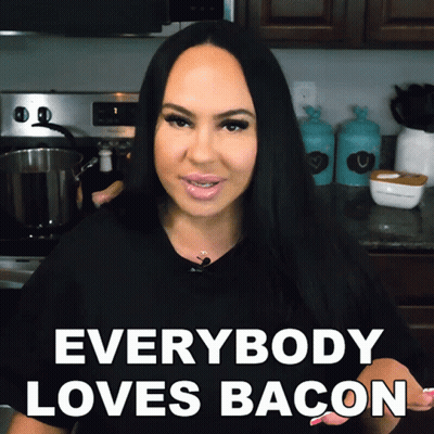 A Woman In A Kitchen With The Words " Everybody Loves Bacon " GIF