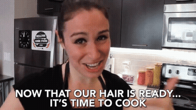 A Woman In A Kitchen With The Words Now That Our Hair Is Ready It 'S Time To Cook GIF