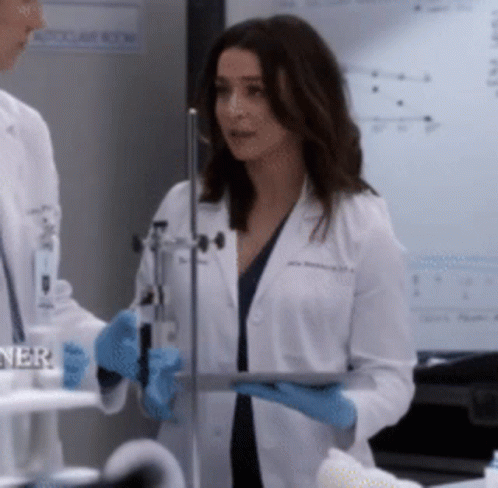 A Woman In A Lab Coat Holding A Tablet GIF