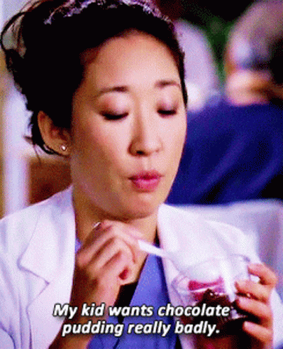 A Woman In A Lab Coat Is Eating Chocolate Pudding With The Words " My Kid Wants Chocolate Pudding Really Badly " Below H GIF