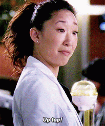 A Woman In A Lab Coat Is Holding A Trophy And Says Up Top ! GIF