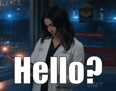 A Woman In A Lab Coat Is Standing In Front Of A Sign That Says " Automatic Sliding Door " GIF