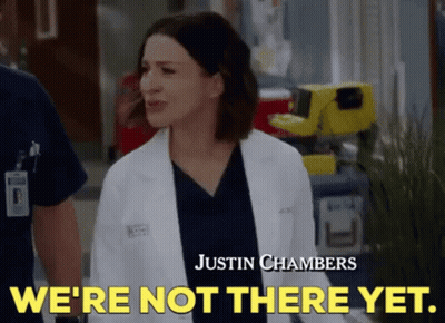 A Woman In A Lab Coat Is Standing Next To A Man In Scrubs And Says `` We 'Re Not There Yet . '' GIF