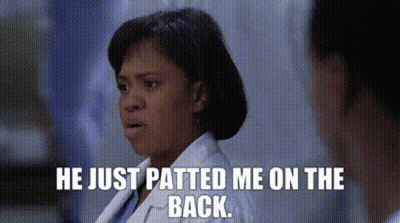 A Woman In A Lab Coat Is Talking To A Man In A Hospital Room And Says He Just Patted Me On The Back . GIF