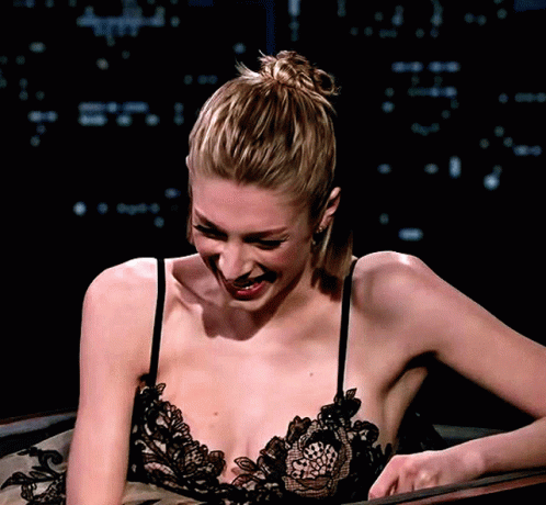 A Woman In A Lace Bra Is Smiling And Looking Down GIF