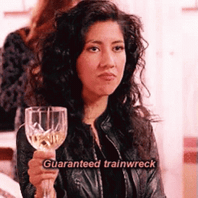 A Woman In A Leather Jacket Is Holding A Wine Glass With The Words `` Guaranteed Trainwreck '' Written On It . GIF