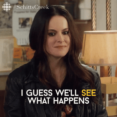 A Woman In A Leather Jacket Is Sitting In Front Of A Lamp And Saying `` I Guess We 'Ll See What Happens '' GIF