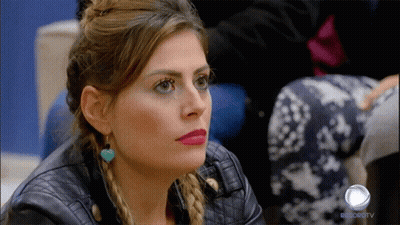 A Woman In A Leather Jacket Is Sitting In Front Of A Record Tv Logo GIF