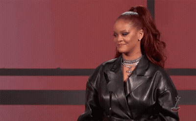 A Woman In A Leather Jacket Is Standing In Front Of A Microphone And Giving A Speech . GIF