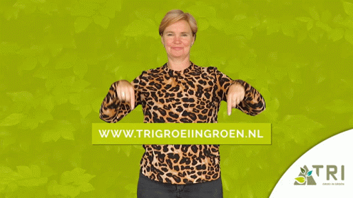 A Woman In A Leopard Print Shirt Is Pointing To A Green Banner That Says Www.trigroeiingroen.nl GIF