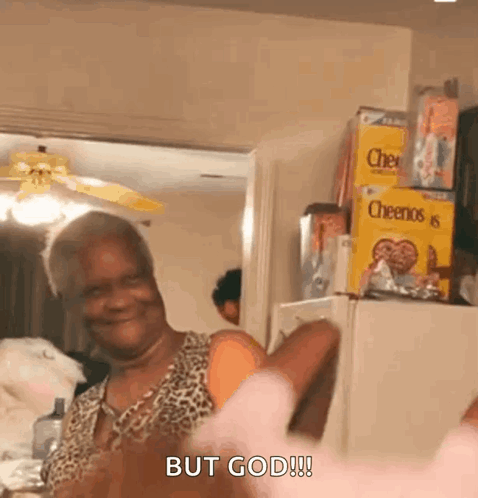 A Woman In A Leopard Print Shirt Is Standing In Front Of A Refrigerator . GIF