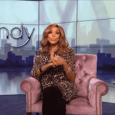 A Woman In A Leopard Print Shirt Sits In A Purple Chair In Front Of A Wall That Says Wendy GIF