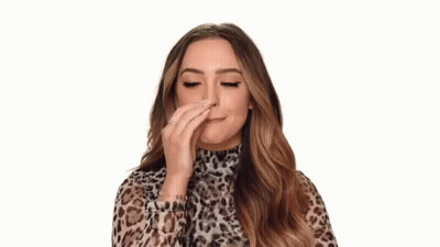 A Woman In A Leopard Print Top Is Making An Ok Sign With Her Hand . GIF