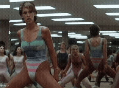 A Woman In A Leotard Is Dancing In A Gym With Other Women GIF