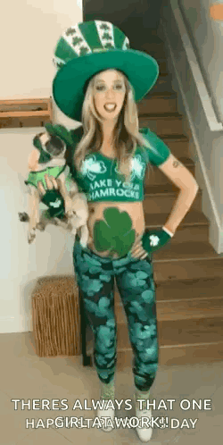 A Woman In A Leprechaun Costume Is Standing On A Set Of Stairs Holding A Small Dog . GIF