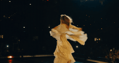 A Woman In A Long White Dress Is Dancing In The Dark GIF