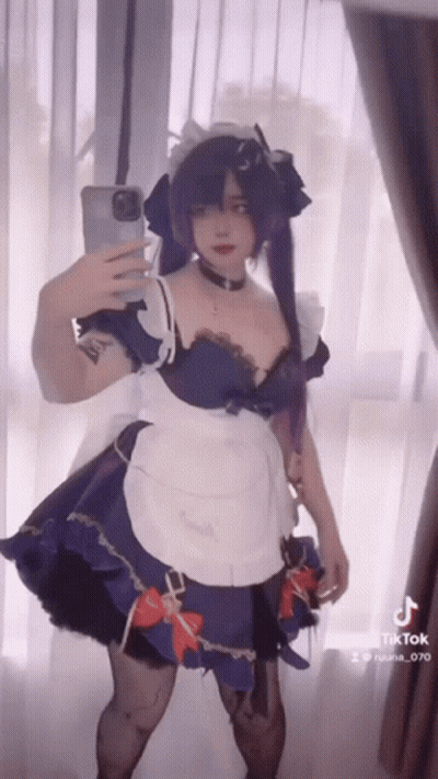 A Woman In A Maid Outfit Is Taking A Selfie GIF