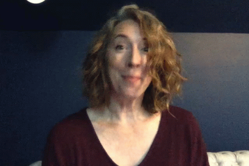 A Woman In A Maroon Shirt Is Making A Face GIF