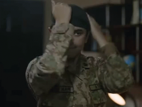 a woman in a military uniform is adjusting her beret .