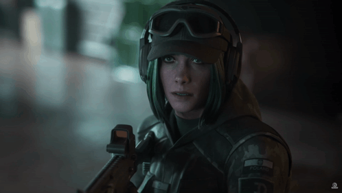 A Woman In A Military Uniform Is Holding A Gun And Has The Letter E On Her Hat GIF