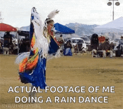 A Woman In A Native American Dress Is Dancing In A Field With The Caption " Actual Footage Of Me Doing A Rain Dance " GIF