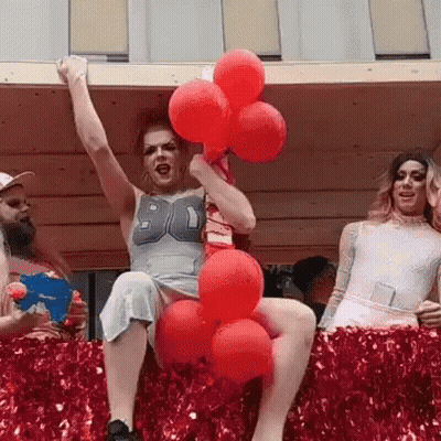 A Woman In A Number 90 Shirt Is Holding Red Balloons In Her Hand GIF
