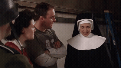 A Woman In A Nun Costume Talks To A Man Wearing A Shirt That Says 32 GIF