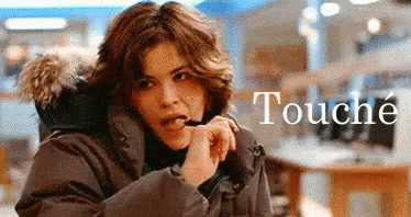 A Woman In A Parka With A Fur Hood Is Talking On A Cell Phone GIF