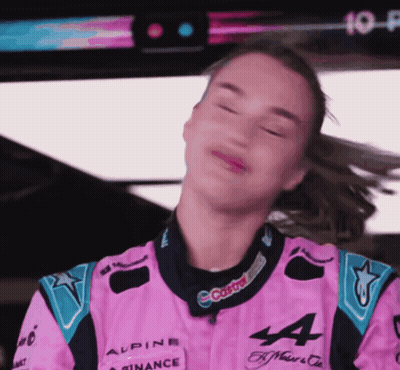 A Woman In A Pink Alpine Racing Suit Is Making A Face GIF