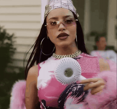 A Woman In A Pink And White Dress Is Holding A Fan GIF