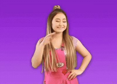 A Woman In A Pink Apron With A Hello Babe Pin On It GIF