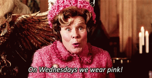 A Woman In A Pink Coat And Hat Says On Wednesdays We Wear Pink . GIF