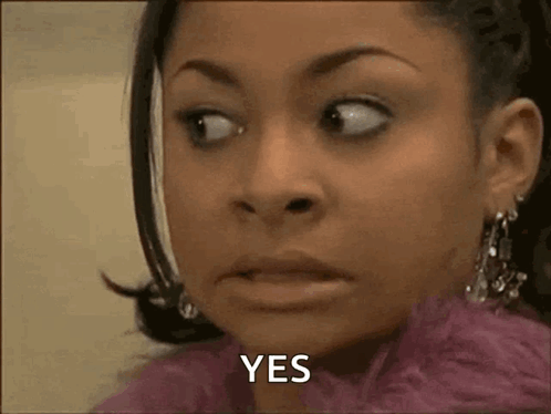 A Woman In A Pink Coat Is Making A Funny Face And Saying Yes . GIF