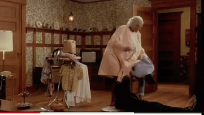 A Woman In A Pink Coat Is Standing In A Room GIF