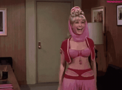 A Woman In A Pink Costume Is Dancing In A Living Room GIF