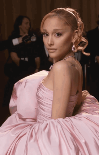 A Woman In A Pink Dress Has A Tattoo On Her Shoulder GIF