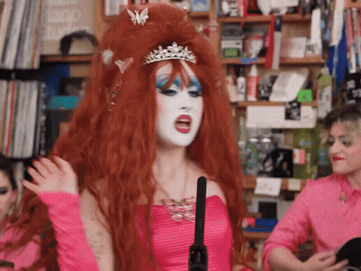A Woman In A Pink Dress Has A Tiara On Her Head GIF