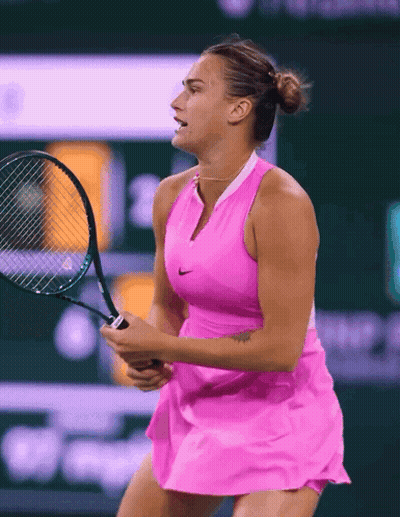 A Woman In A Pink Dress Holding A Tennis Racquet GIF
