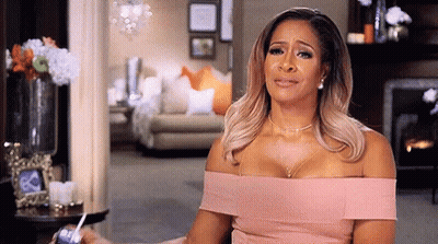 A Woman In A Pink Dress Is Crying In A Living Room . GIF