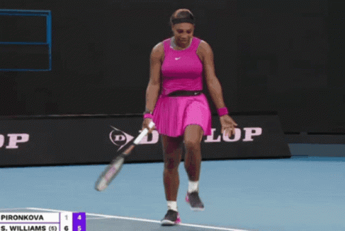 A Woman In A Pink Dress Is Holding A Tennis Racquet In Front Of A Dunlop Banner GIF
