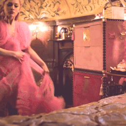 A Woman In A Pink Dress Is In A Room GIF