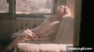 A Woman In A Pink Dress Is Laying On A Couch With Her Eyes Closed GIF