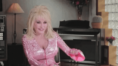 A Woman In A Pink Dress Is Sitting In Front Of A Piano And Holding A Pink Shoe . GIF
