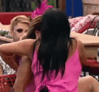 A Woman In A Pink Dress Is Sitting Next To Another Woman . GIF